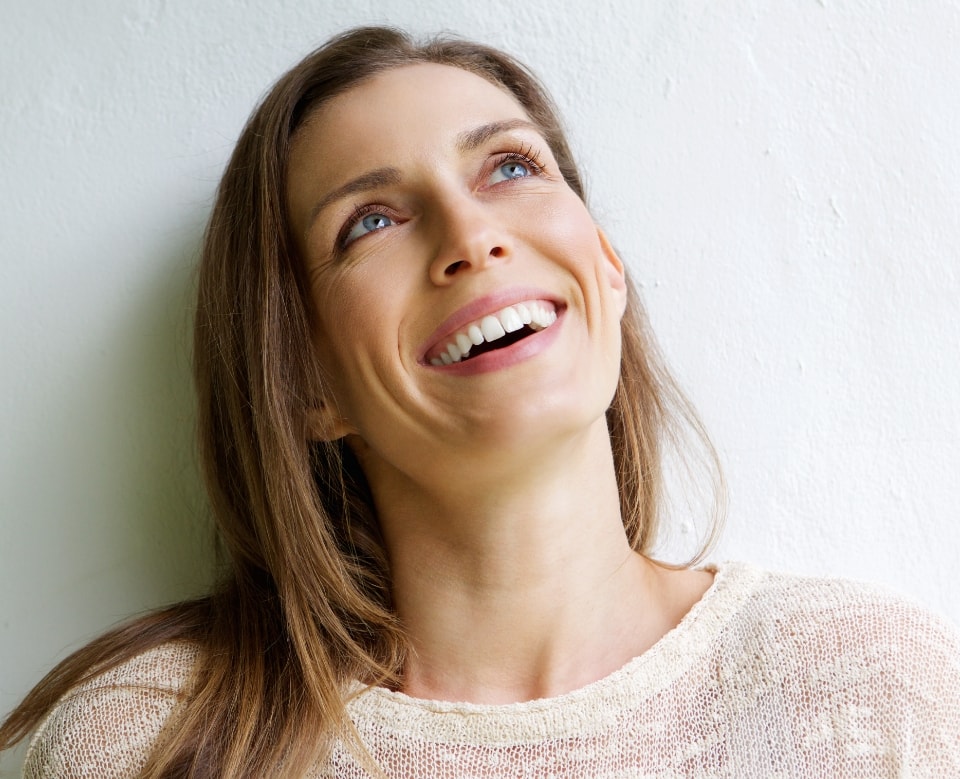 Close up of a woman standing in front of a wall and looking up