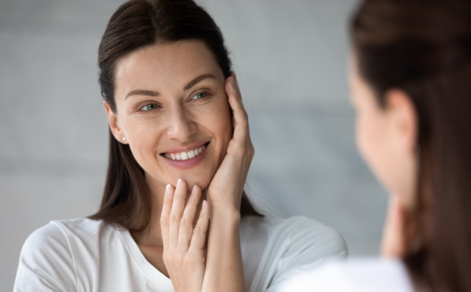 Woman smiling and holding her face with her hands